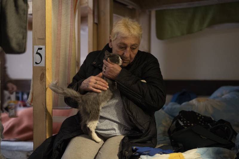 Alexandra Kusminova pets her cat, named Mouse, in a restaurant in Dnipro, Ukraine, that was transformed into a shelter for those fleeing the war. AP