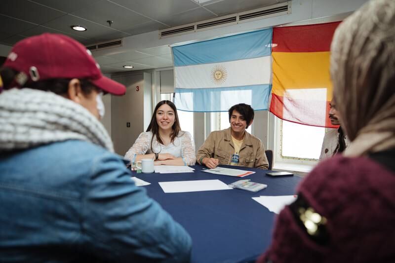 Logos Hope crew members Sofia from Argentina and Dennis from Ecuador hold conversations in Spanish at a language practice event.