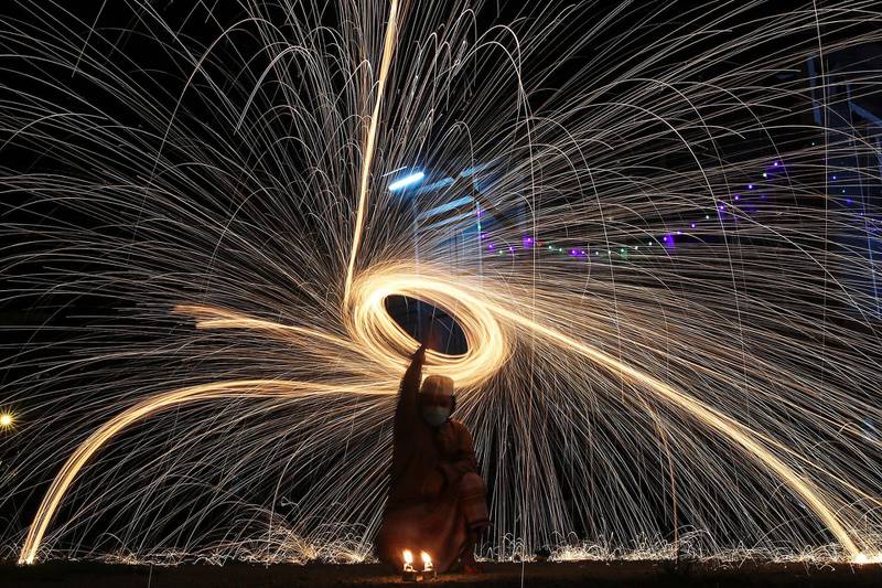 A man swings around fireworks ahead of Eid Al Fitr celebrations, the religious festival that marks the end of Ramadan, amid the ongoing coronavirus pandemic in Klang, outside Kuala Lumpur, Malaysia. EPA