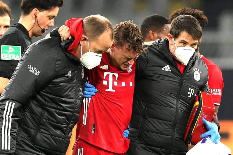 Injured Bayern midfielder Joshua Kimmich is helped from thew pitch. EPA