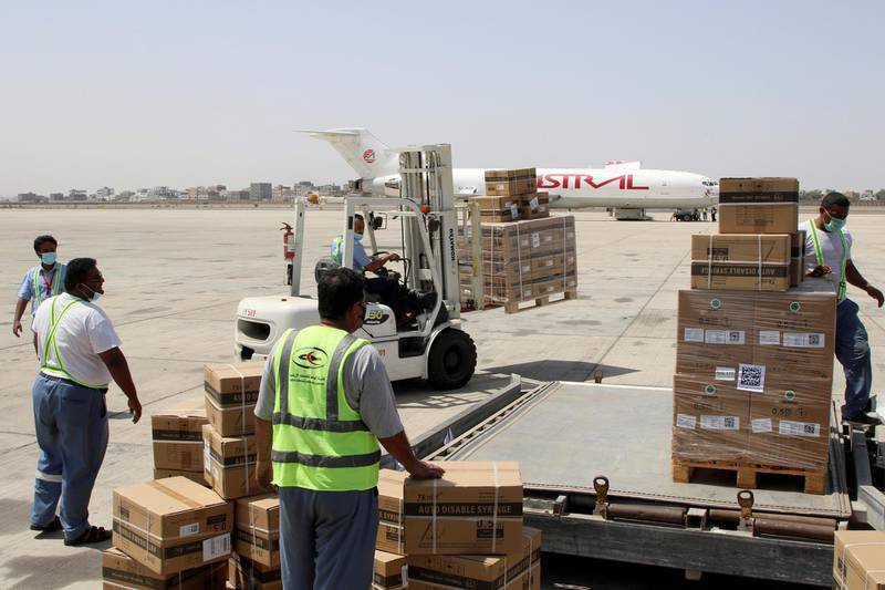 Workers handle the first batch of doses of the AstraZeneca vaccine at Aden International Airport, Yemen. Reuters