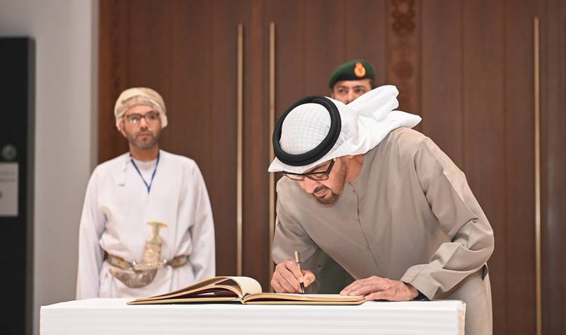 Sheikh Mohamed writes a message in the museum's guestbook. 

