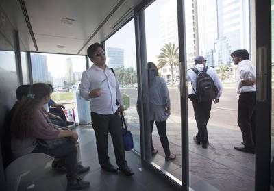 Hot and bothered passengers wait for a bus inside a shelter located on Muroor Road near the Madinat Zayed shopping mall and the Gold Centre in Abu Dhabi, just of the many shelters with a malfunctioning AC or defective automatic doors. Ravindranath K / The National