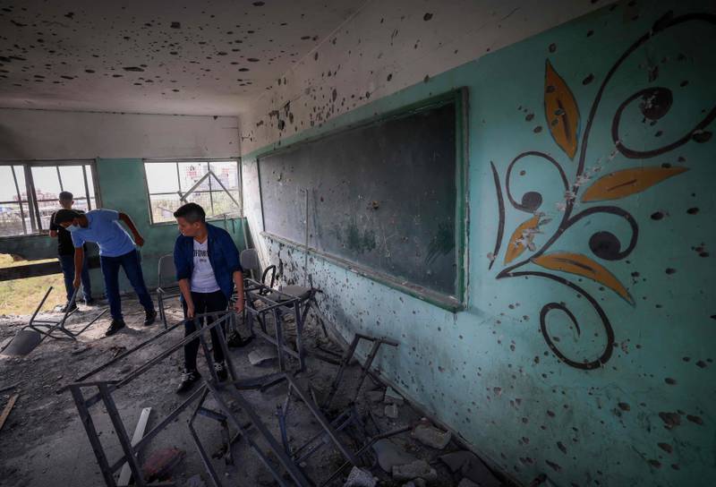 On the first day of the new academic year in Gaza City, Palestinian pupils inspect a classroom that was damaged by sir strikes. AFP