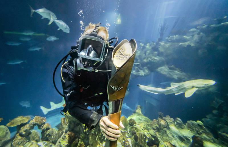 The diver Sebastian Prajsnar carries the Queen's Baton for the 2022 Commonwealth Games, to be held in Birmingham, in the aquarium at The Deep sea-life attraction as the baton visits Yorkshire on its 25-day tour of England. The opening ceremony is on July 28. AP