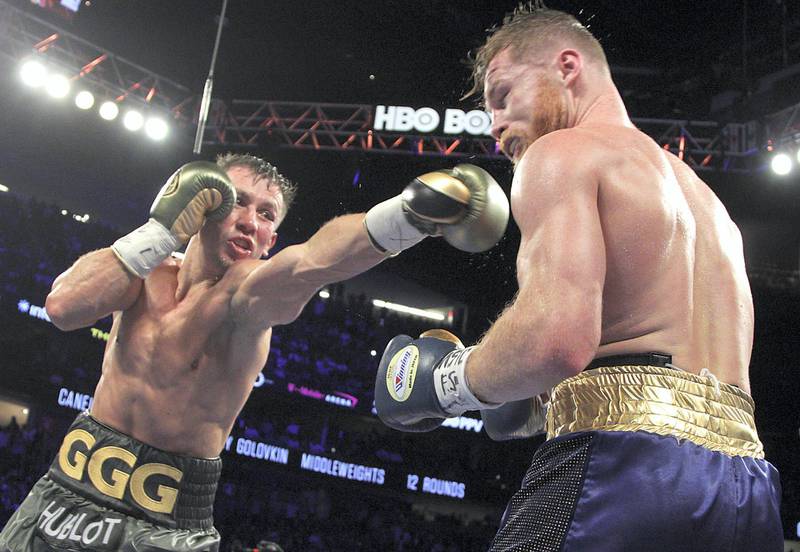 Gennady Golovkin (L) extends a left against Canelo Alvarez (R) during their WBC, WBA and IBF middleweight championship fight at the T-Mobile Arena on September 16, 2017 in Las Vegas, Nevada. 
Gennady Golovkin retained his three world middleweight titles, fighting to a draw with Mexican star Canelo Alvarez in a showdown for middleweight supremacy that lived up the hype.
 / AFP PHOTO / John GURZINSKI