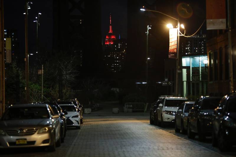 Washington Street is empty as the Empire State building is lit in red and white lights to honor emergency medical workers in the Brooklyn borough of New York. AP Photo