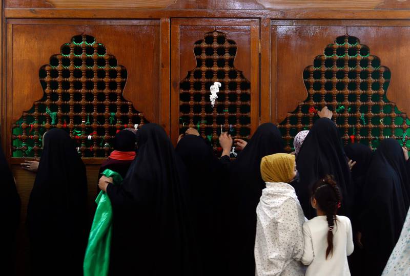Shiite Muslim pilgrims touch the tomb of Imam Abbas in Karbala, Iraq. AP Photo