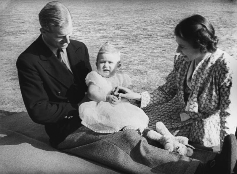 A young Prince Charles is perched on the lap of his father the Duke of Edinburgh, while his mother Queen Elizabeth II looks on in the grounds of Windlesham Moor in 1949. All photos: Getty Images unless otherwise indicated
