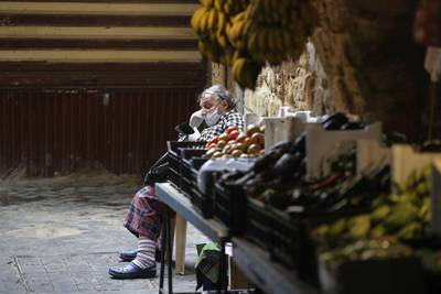 A Lebanese man sitting by a fresh produce stall checks his phone in the market of the historic part of the southern coastal city of Saida. Lebanon's President called on international donors to provide financial assistance to the crisis-hit country as it grapples with a severe economic downturn compounded by the novel coronavirus pandemic. AFP