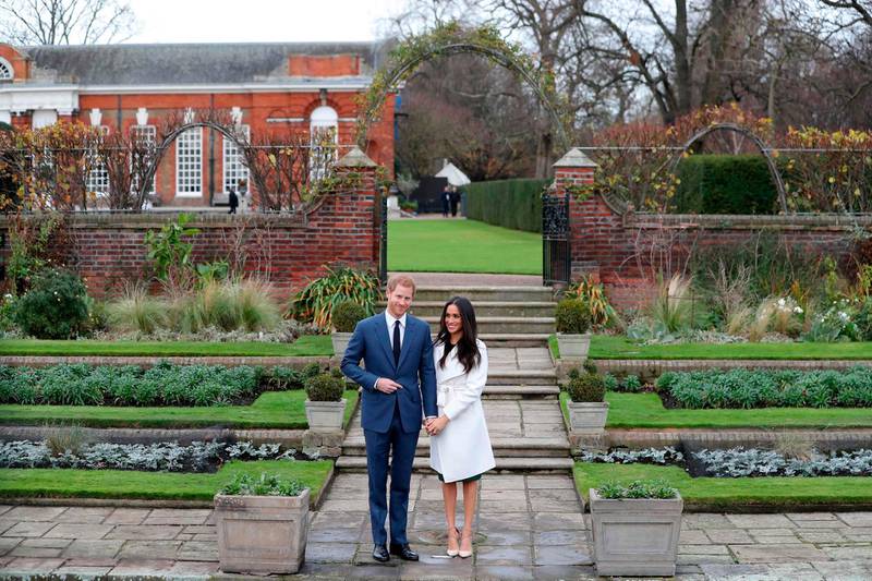(FILES) In this file photo taken on November 27, 2017 Britain's Prince Harry and his fiancée US actress Meghan Markle pose for a photograph in the Sunken Garden at Kensington Palace in west London on November 27, 2017, following the announcement of their engagement. Kensington Palace, the marital home of Prince Harry and his bride-to-be Meghan Markle, plays host to several royals including his brother Prince William's growing clan. / AFP / Daniel LEAL-OLIVAS
