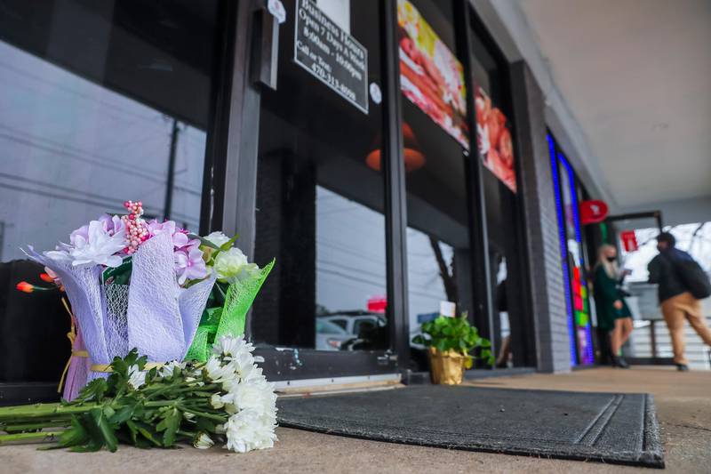 epa09080246 Flowers left by well-wishers sit at the entrance to Young's Asian Massage spa in Acworth, Georgia, USA, 17 March 2021. Robert Aaron Long, 21, has been apprehended in the shooting spree which left eight people dead at three metro Atlanta massage parlors, including seven women of Asian descent.  EPA/ERIK S. LESSER