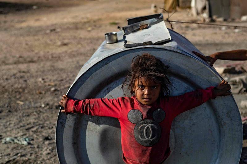 A child grips a water tank at Sahlah Al Banat camp in Raqa, Syria. The World Health Organisation has issued a warning of a ‘very high’ risk of cholera spreading throughout the country, when 342 cases were recently confirmed. AFP
