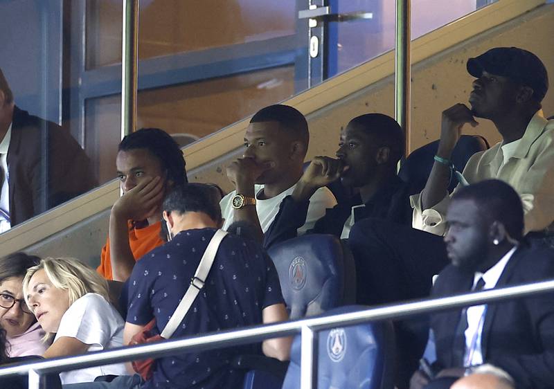 Kylian Mbappe watches the match against Llorient alongside PSG new boy Ousmane Dembele. Reuters