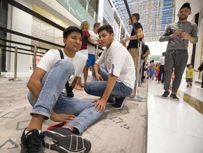 DUBAI, UNITED ARAB EMIRATES, 20 SEPTEMBER 2018 - Imat Musaev from Uzbekistan with his friend waiting in queue to get the new iphone XS at Apple store in Dubai Mall.  Leslie Pableo for The National for Patrick Ryan’s story