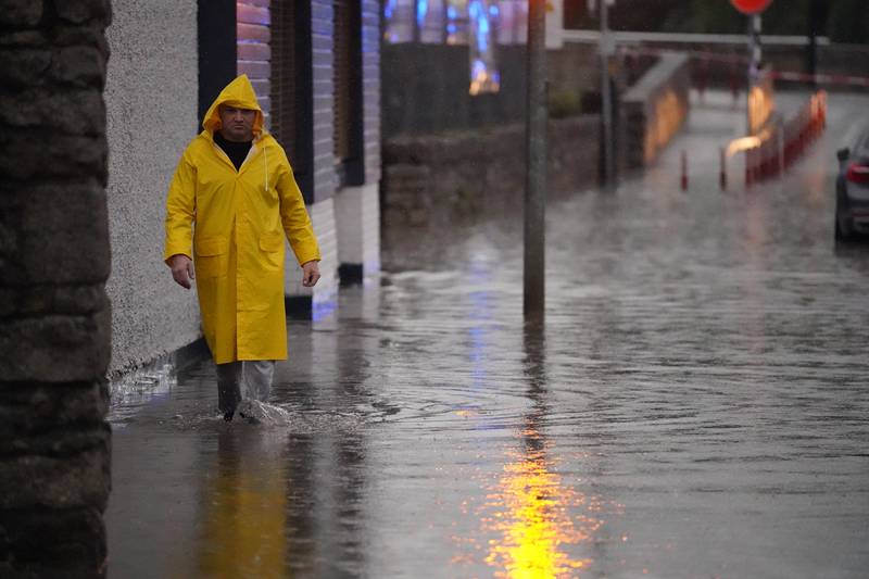 A resident makes his way through the flooding in Tullow in Ireland. PA