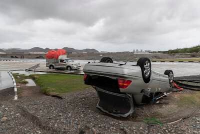 An overturned car in Fujairah city beside a flooded road.
Antonie Robertson / The National
