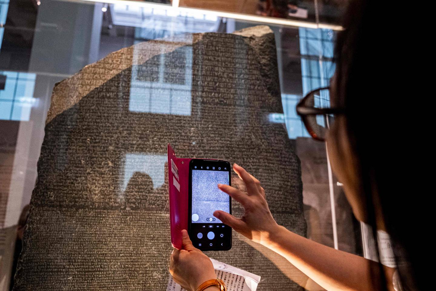 A visitor takes pictures of the Rosetta Stone at the British Museum. AFP