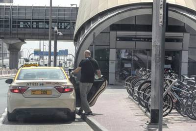 DUBAI, UNITED ARAB EMIRATES. 13 APRIL 2020. General STANDALONE image of Dubbai streets during the COVID-19 Lockdown of Dubai. A man takes a taxi cab after leaving the Business Bay Metro station. (Photo: Antonie Robertson/The National) Journalist: Standalone. Section: National.