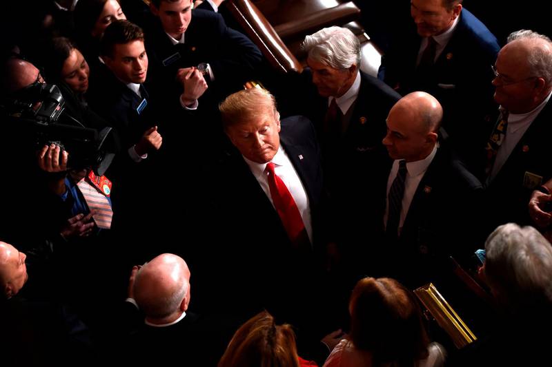 Donald Trump is surrounded by people after delivering the State of the Union address. AFP