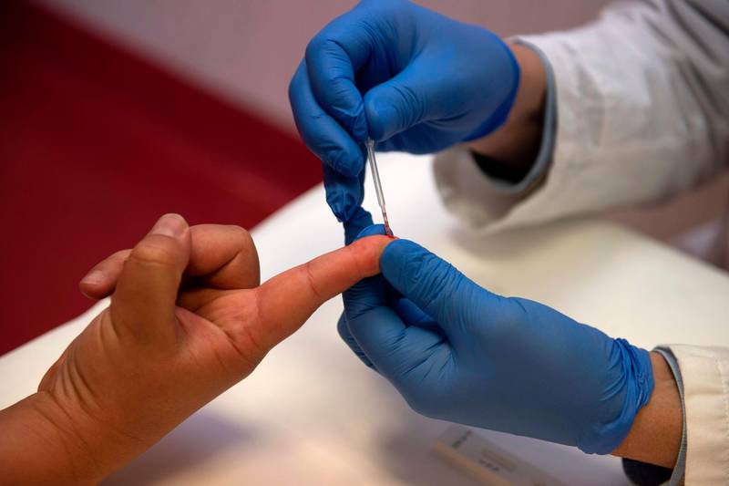 A person undergoes a finger prick blood sample as part of of an antibody rapid serological test for COVID-19 on May 6, 2020 at the Tor Vergata Covid hospital in Rome, during the country's lockdown aimed at curbing the spread of the COVID-19 infection, caused by the novel coronavirus.  / AFP / Tiziana FABI
