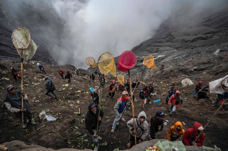Members of the Tengger sub-ethnic group use nets to catch offerings thrown by other devotees into the crater of the active Mount Bromo volcano as part of the Yadnya Kasada festival in Probolinggo, Indonesia. AFP