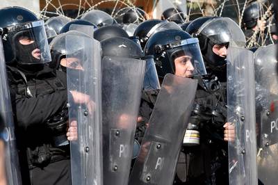 Anti-riot policemen react as protesters throw stones during a demonstration against parliament session on 2020 budget in downtown Beirut.  EPA