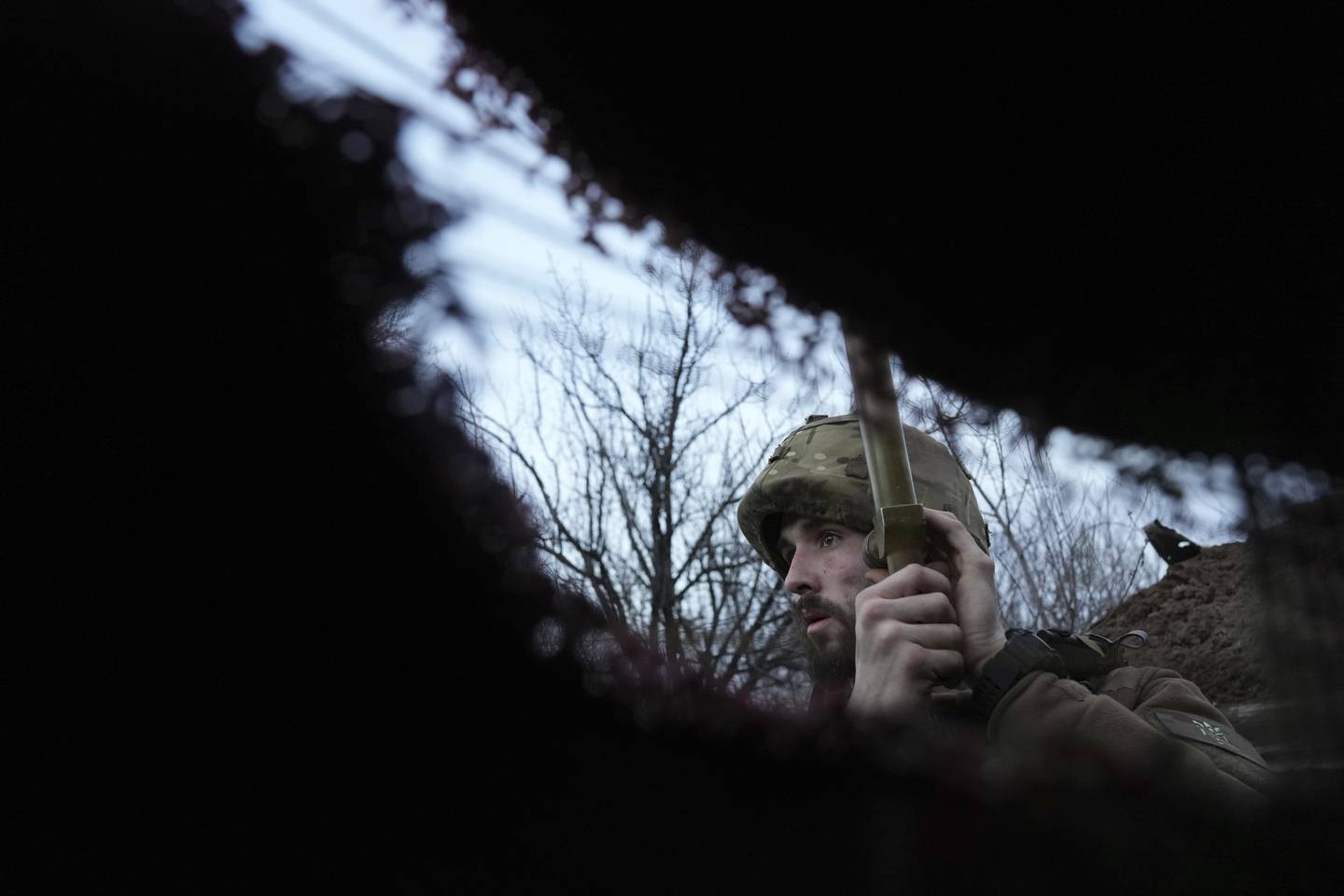 A Ukrainian troop listens to artillery fire in a trench near Zolote, Ukraine. AP Photo