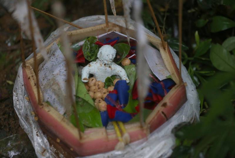 Relatives make a effigy offering food.   Sakchai Lalit / AP Photo