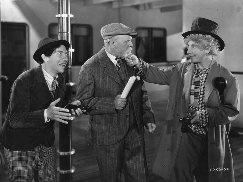 1931:  Chico (1887 - 1961) and Harpo Marx (1888 - 1964) pull an old man's beard in the Marx Brothers film 'Monkey Business', directed by Norman McLeod and produced by Paramount Pictures.  (Photo by Hulton Archive/Getty Images)