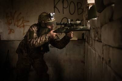 A sniper searches for Russian positions on the bank of the Dnipro river in Kherson in November 2022. Getty Images