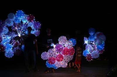 A vendor sells LED balloons in full darkness at the corniche in Beirut. EPA