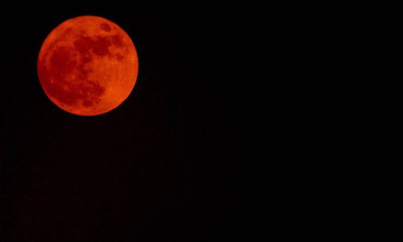 The moon glows red near government buildings in New Delhi. AFP