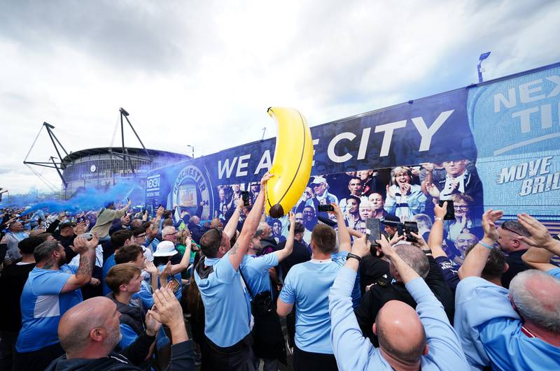 Manchester City fans surround the team bus. PA