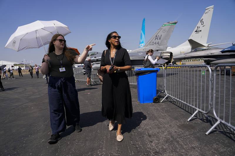Visitors shelter from the sun as they look around the show. AP
