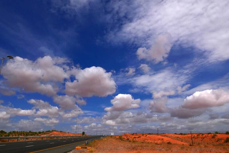 Clouds, mountains and the red sand of the Northern Emirates. 