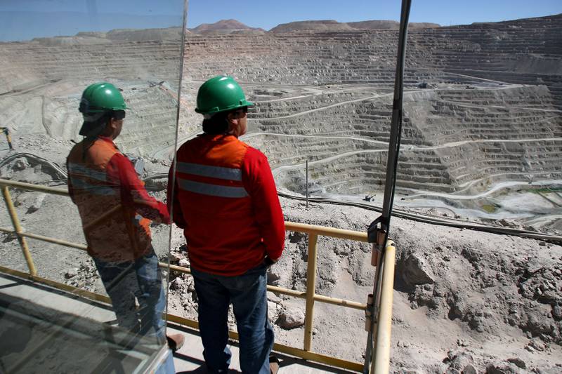 Workers stand over BHP Billiton's Escondida, the world's biggest copper mine, in Antofagasta, Chile. Reuters