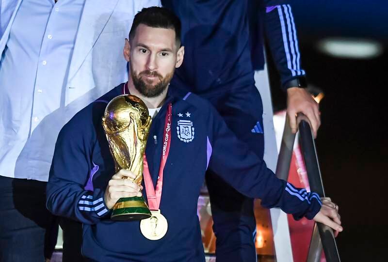 Argentina captain Lionel Messi with the World Cup trophy after arriving at Ezeiza International Airport. Getty