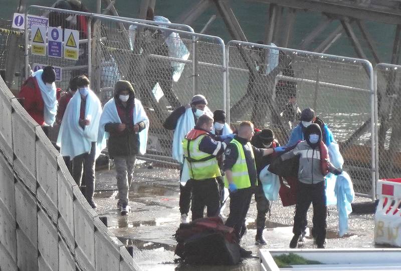 A group of people thought to be migrants are led through the Border Force compound in Dover, Kent, following a small boat incident in the Channel. PA