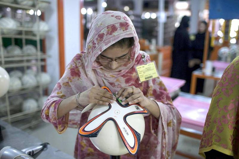 An employee adjusts outer panels of a soccer ball inside the football factory that produces official match balls for the 2014 World Cup in Brazil, in Sialkot, Punjab province. Sara Farid / Reuters

