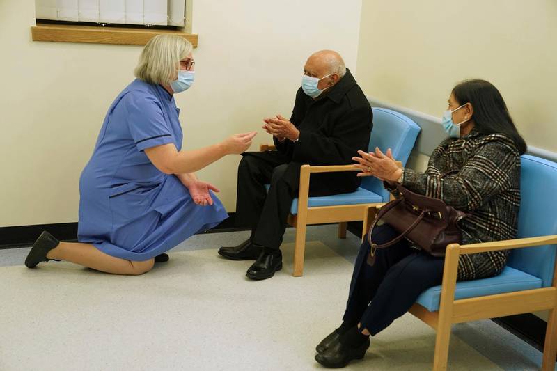 Retired nurse Suzanne Medows speaks to race relations campaigner Dr Hari Shukla, 87, and his wife Ranju, before he receives the Pfizer-BioNTech Covid-19 vaccine at the Royal Victoria Infirmary in Newcastle. AP Photo