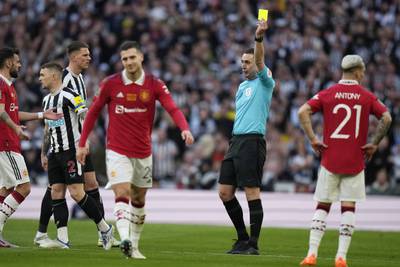 Referee David Coote shows a yellow card to Manchester United's Diogo Dalot. AP 