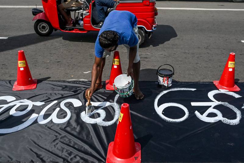 A demonstrator writes a slogan against acting president Ranil Wickremesinghe. AFP