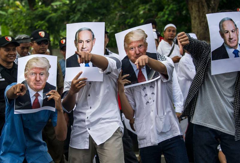 Protesters pose with cutout portraits of US president Donald Trump and Israeli prime minister Benjamin Netanyahu outside US consulate general in Surabaya in Indonesia's East Java province on December 8, 2017. Juni Kriswanto / AFP