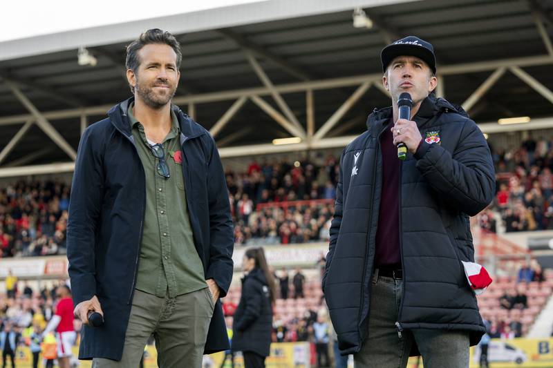 This image released by FX shows Ryan Reynolds, left, and Rob McElhenney in a scene from the docuseries "Welcome to Wrexham," which follows Reynolds and McElhenney as they takeover the lower-league Welsh soccer team Wrexham AFC.  (Patrick McElhenney / FX via AP)