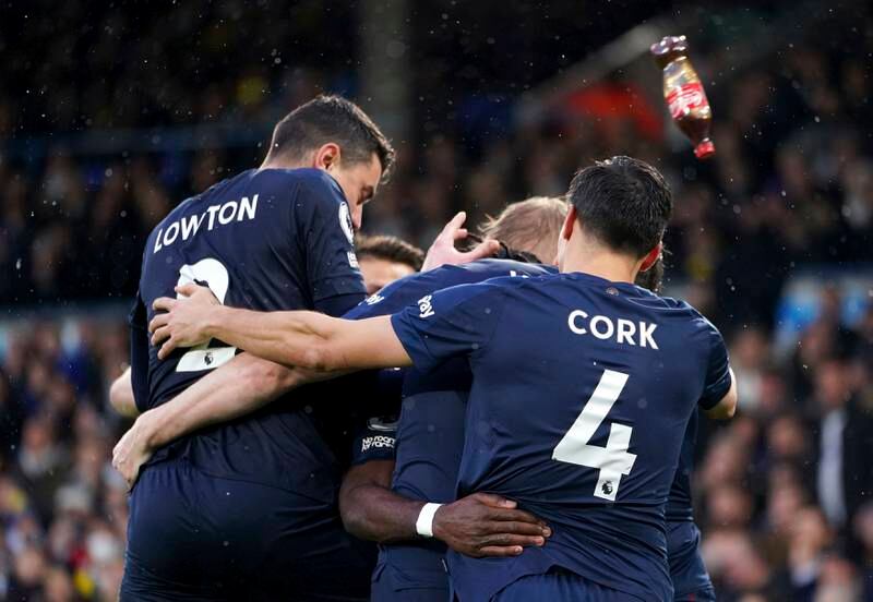 Burnley's Matthew Lowton, left, is hit on the head with a bottle thrown from the stands while celebrating with his teammates after Maxwel Cornet scored against Leeds United at Elland Road on Sunday, January 2, 2022. AP