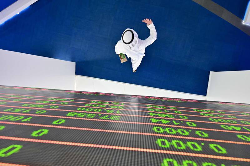 A trader walks by beneath a stock display board at the Dubai Stock Exchange in the UAE on March 8. AFP