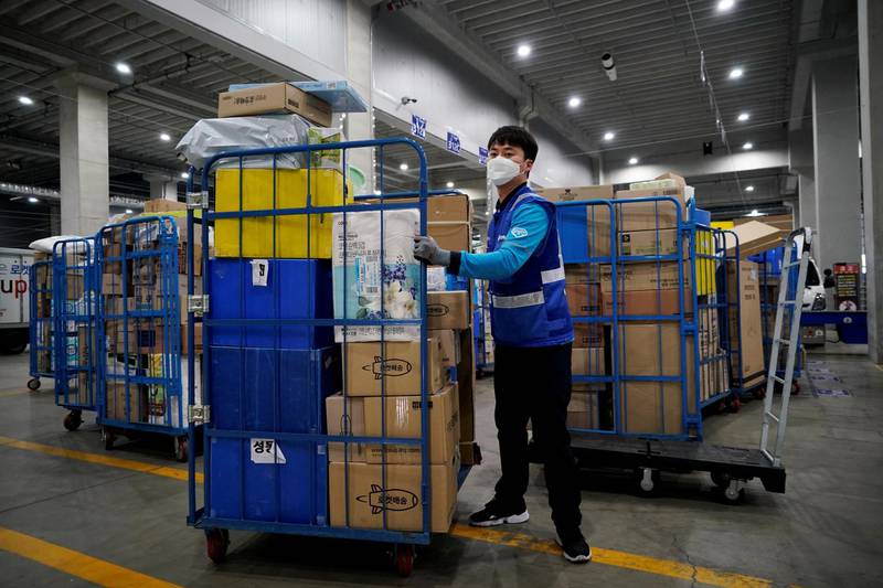 FILE PHOTO: File picture of a delivery man for Coupang wearing a mask to prevent contracting the coronavirus, loading packages before leaving to deliver them in Incheon, South Korea, March 3, 2020. Picture taken on March 3, 2020.  REUTERS/Kim Hong-Ji/File Photo