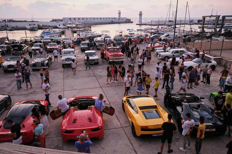 People visit a display of classic and luxury cars at the fishermen's port of the northern Lebanese city of Batroun, on August 6, 2022.  (Photo by Ibrahim CHALHOUB  /  AFP)