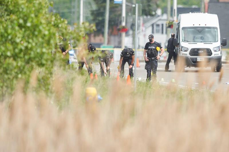 A line of police officers look for evidence at the scene of a car crash in London, Ontario, Canada. Four of five members of a Muslim family were killed when a vehicle struck them in what investigators say was a hate crime. AP Photo